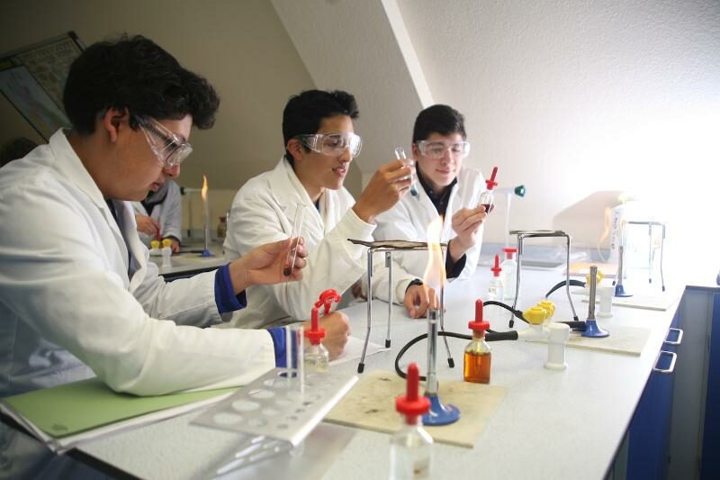Drei Jugendliche beim Experimentieren in einem Labor